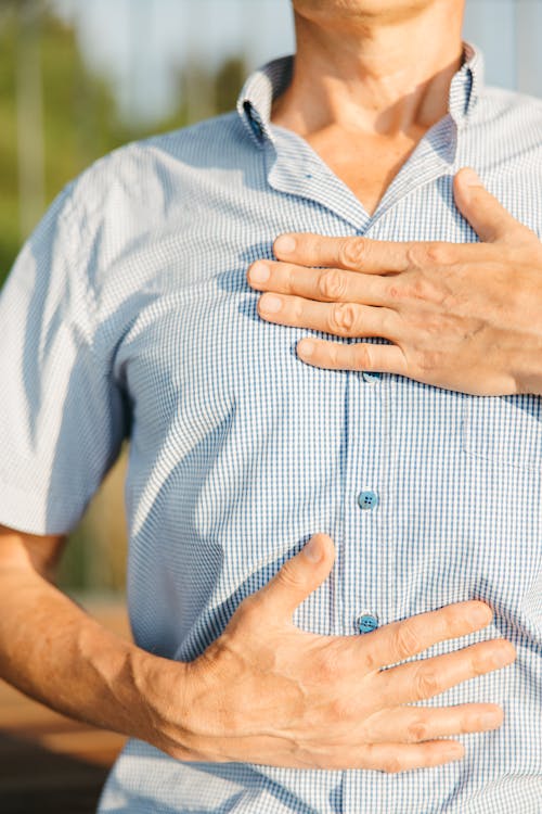 a man with a chest pain holding his chest