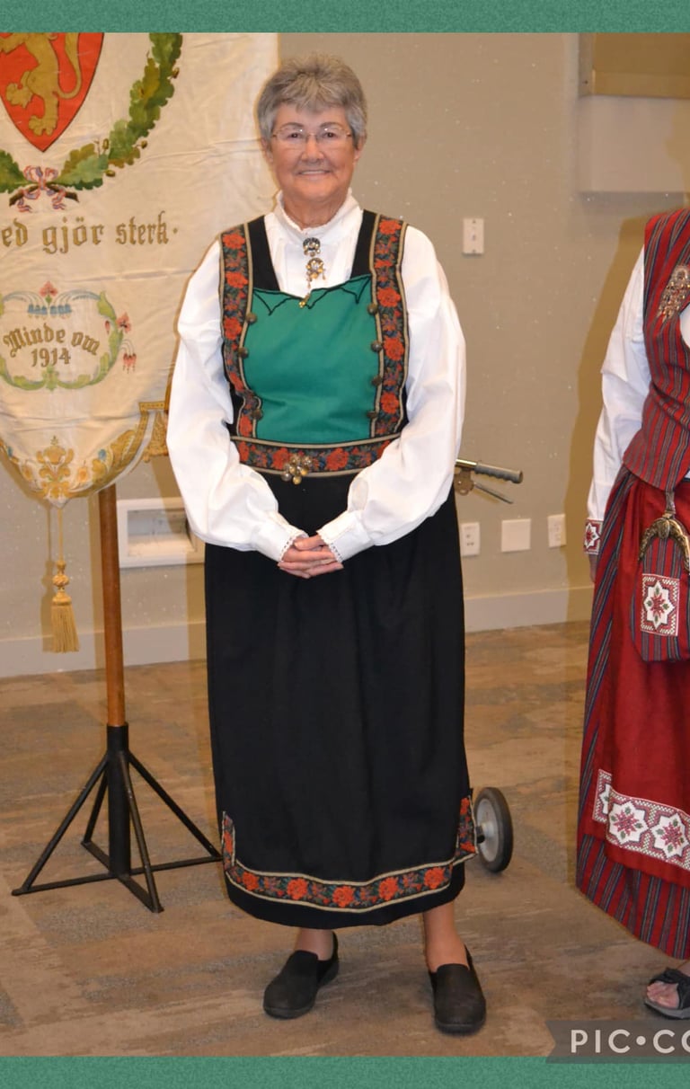 A woman in a Bunad with a green bodice