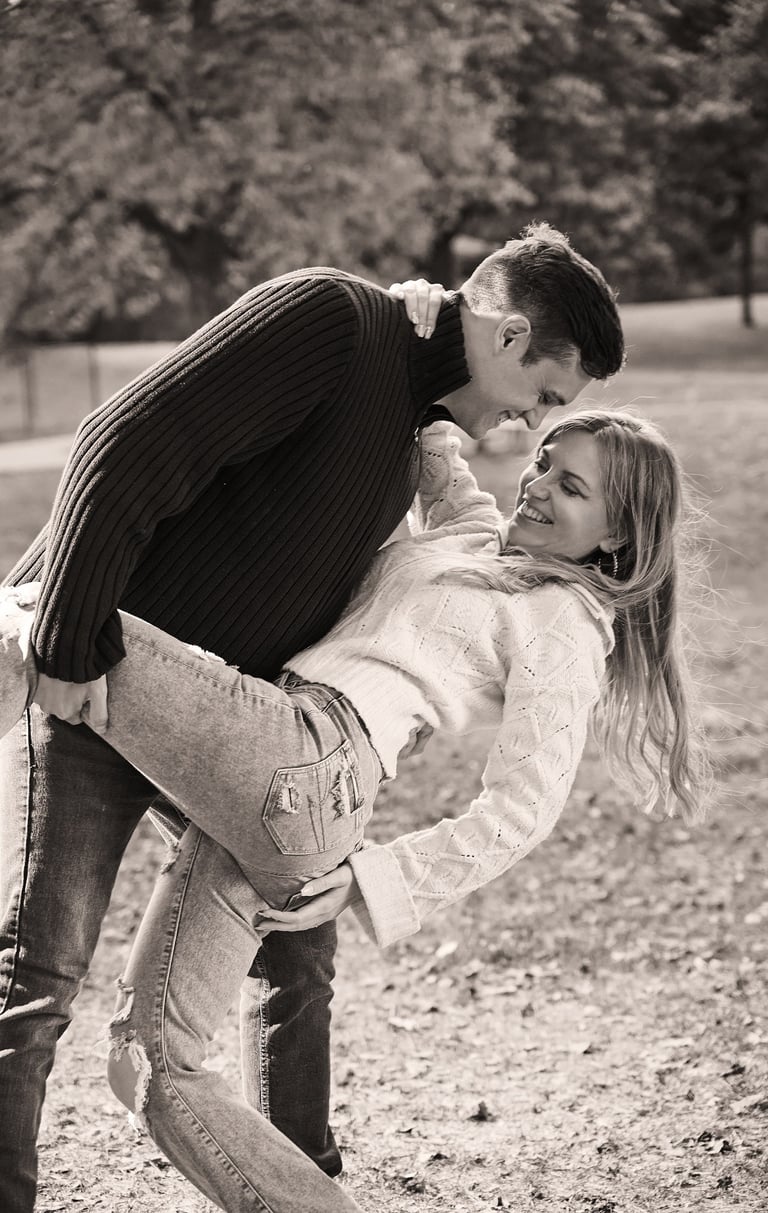 a man holding a woman and bending down to kiss her