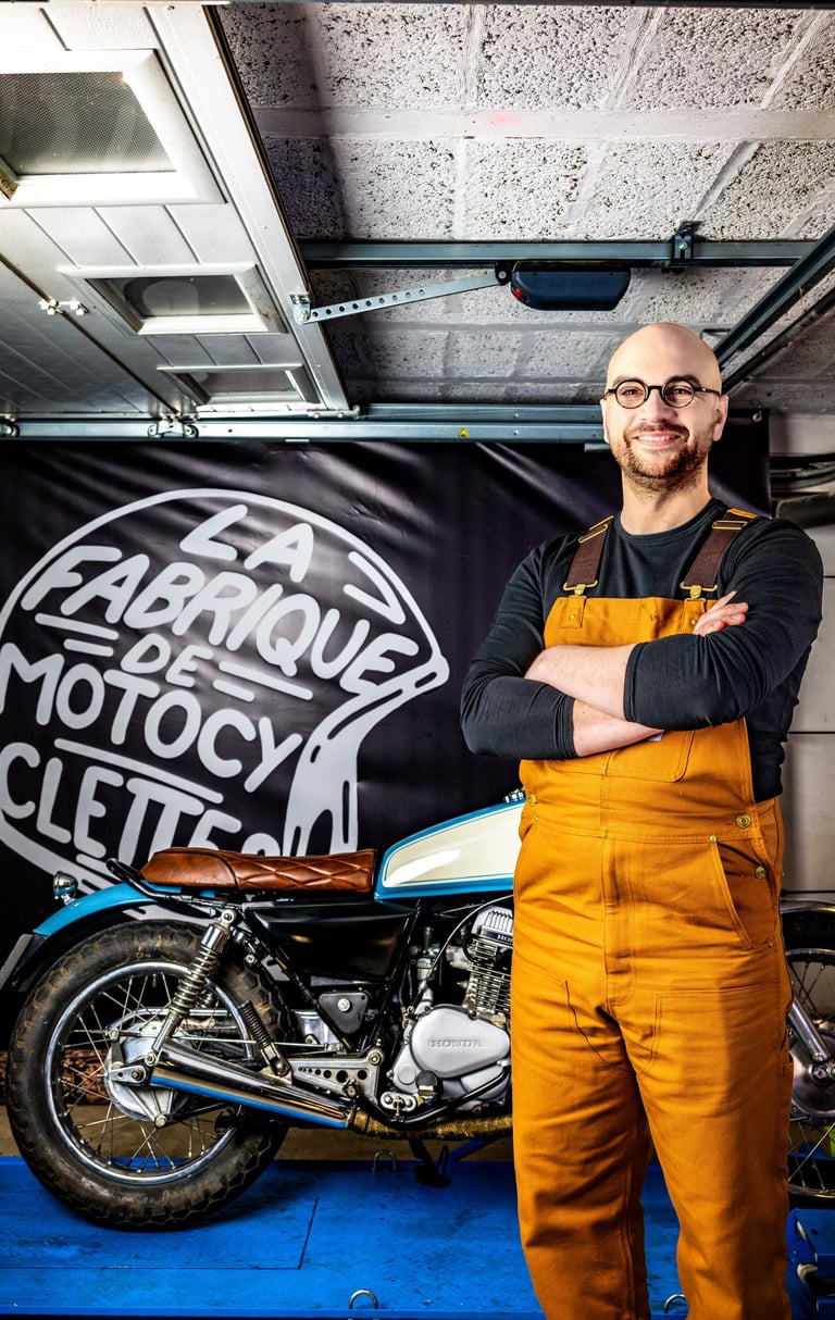 un homme en bleu de travail et en bleu de travail devant une moto