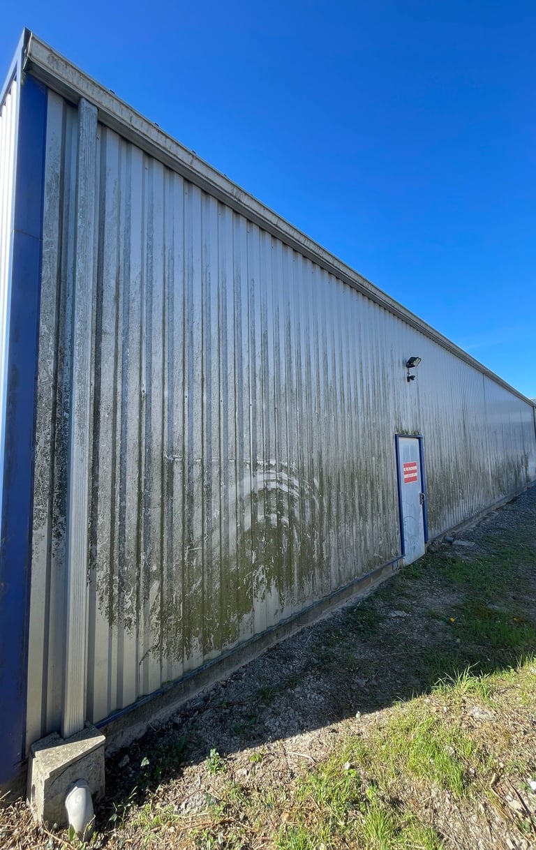 Bardage métallique sale, couvert de mousse et d’algues, à Châteaubriant.