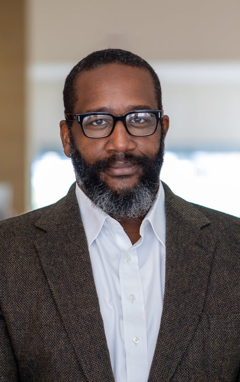 A picture of Dr. Leonard Bright with a beard and glasses on a white background