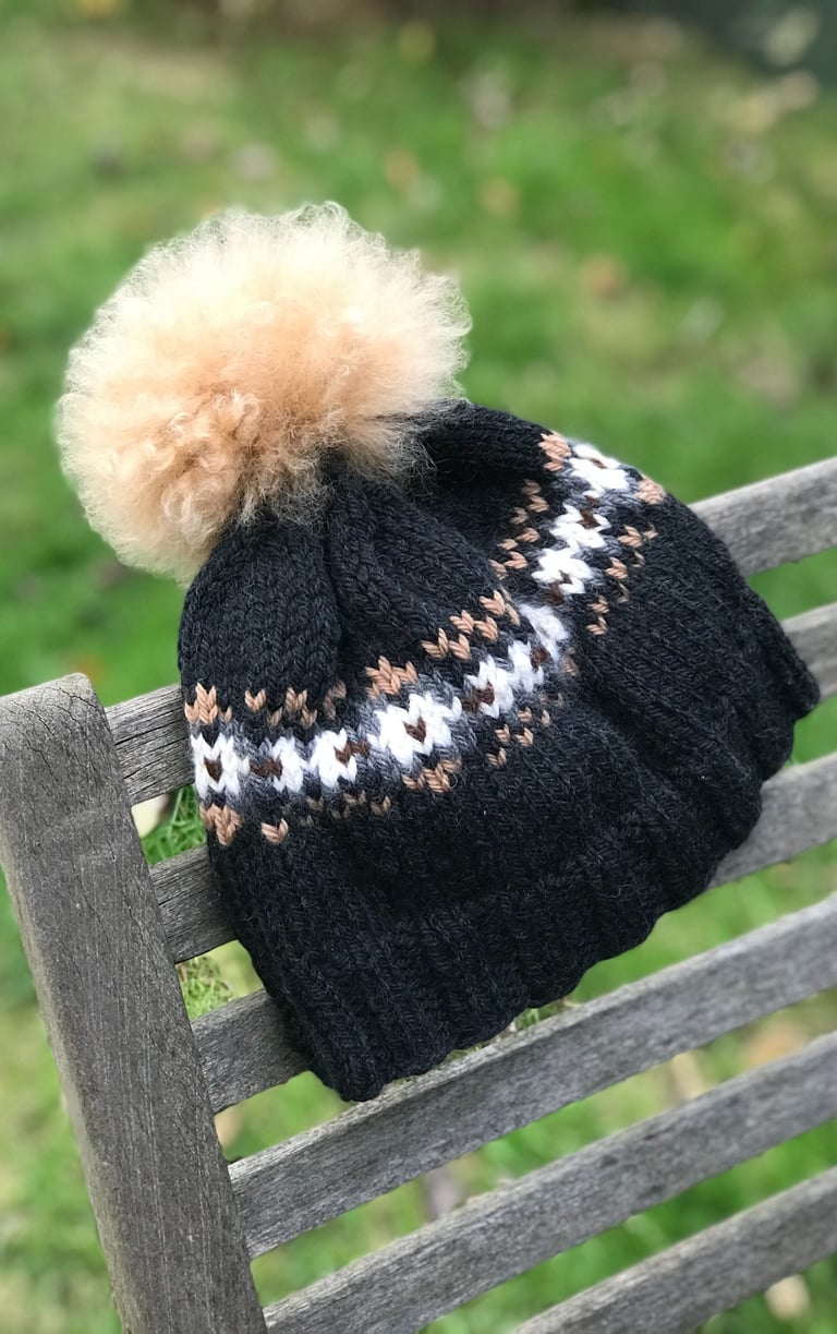 A woolly knit hat with a pom pom and stranded colour work