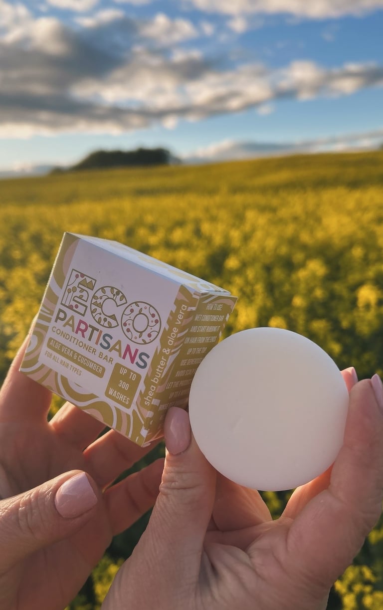 a person holding a soap bar in front of a field