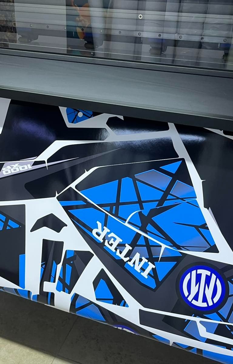 Custom blue and black vinyl graphics for a vehicle being printed on a large format plotter.