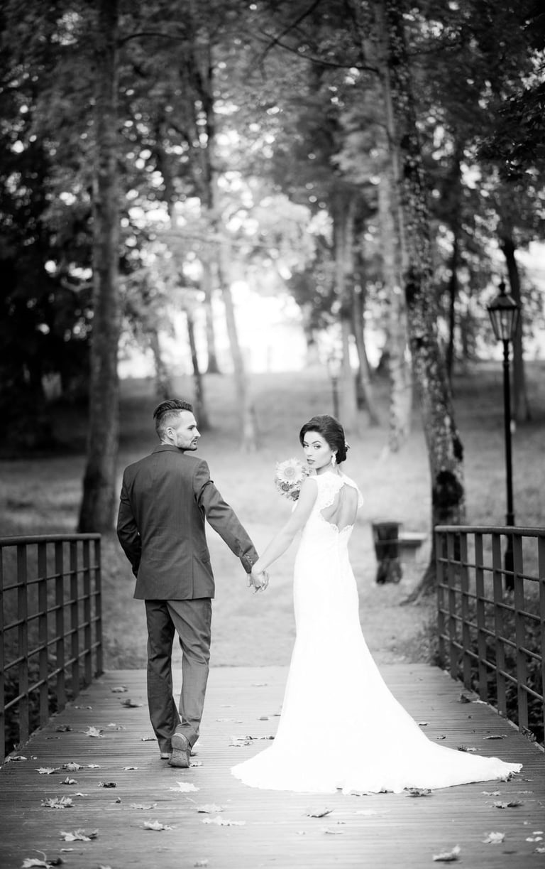 a bride and groom walking down a bridge