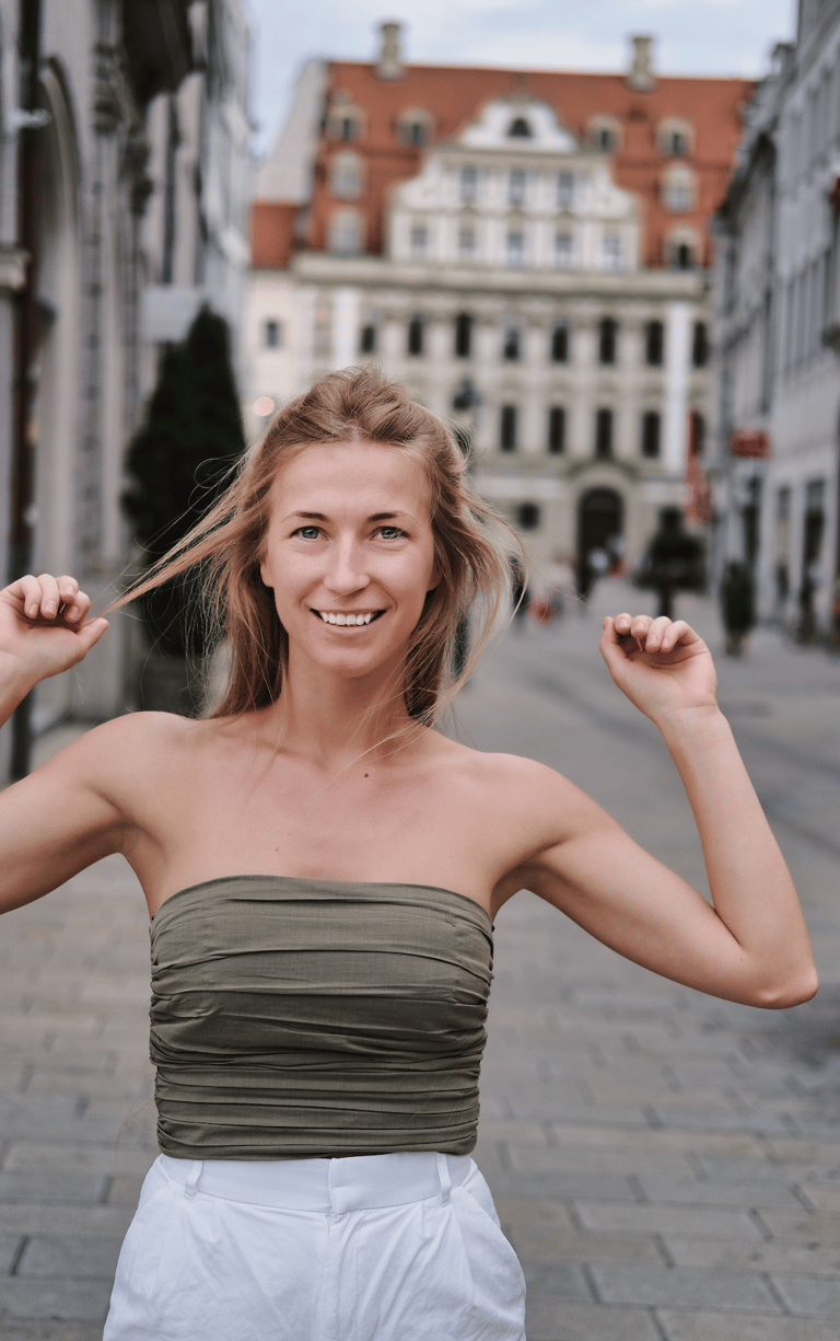 Junge Frau, die auf einer historischen gepflasterten Straße steht.  1 von 3 Varianten
