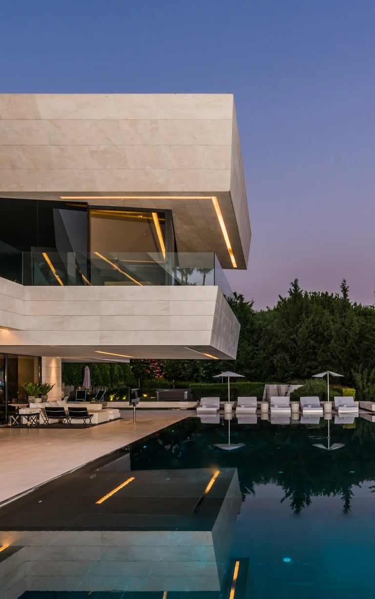 Dusk terrace with illuminated pool and glass façade