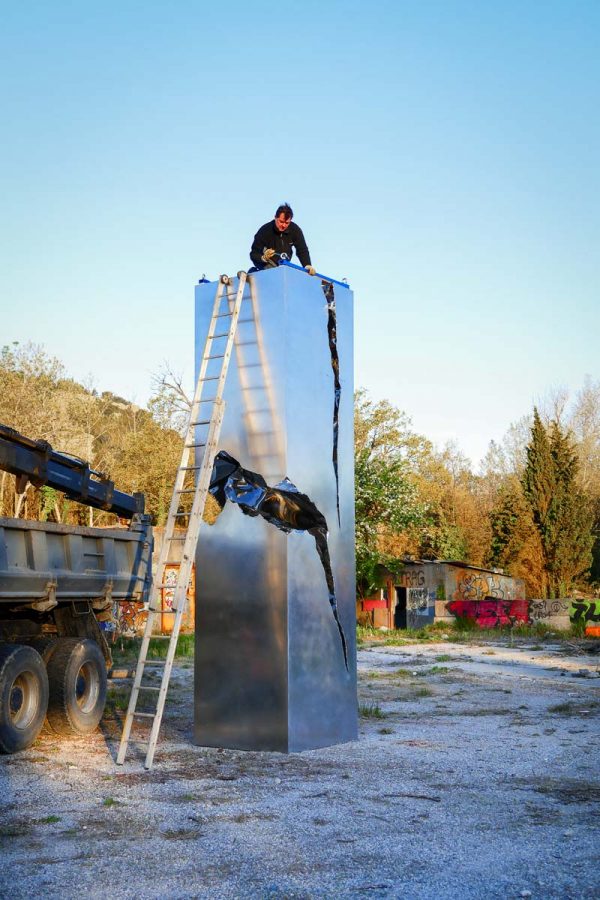 Sculpture de Patrice racois ou on le voit en train de l'installer