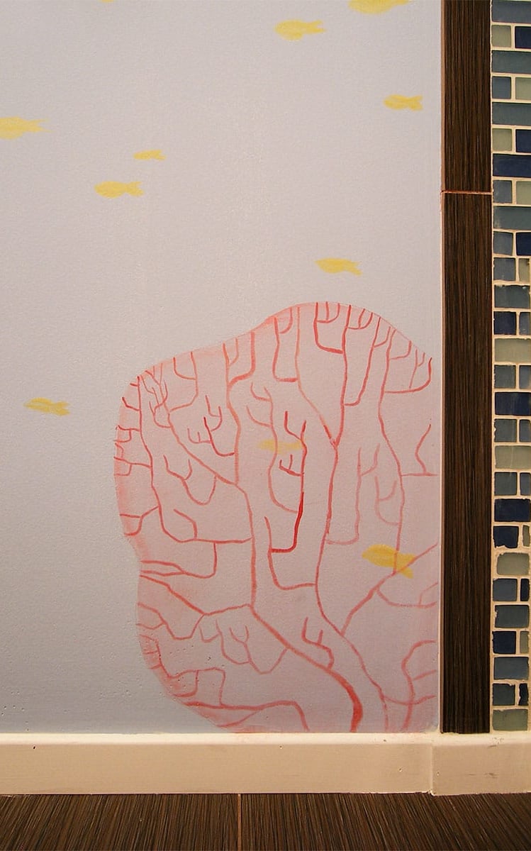 Hand-painted red coral and yellow fish painted in a contemporary style in a kid's bathroom.