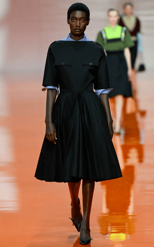 Prada Spring Summer 2026 – Black pleated dress with structured shoulders.