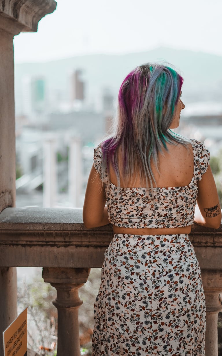 Fotografía de una mujer mirando el horizonte desde un balcón