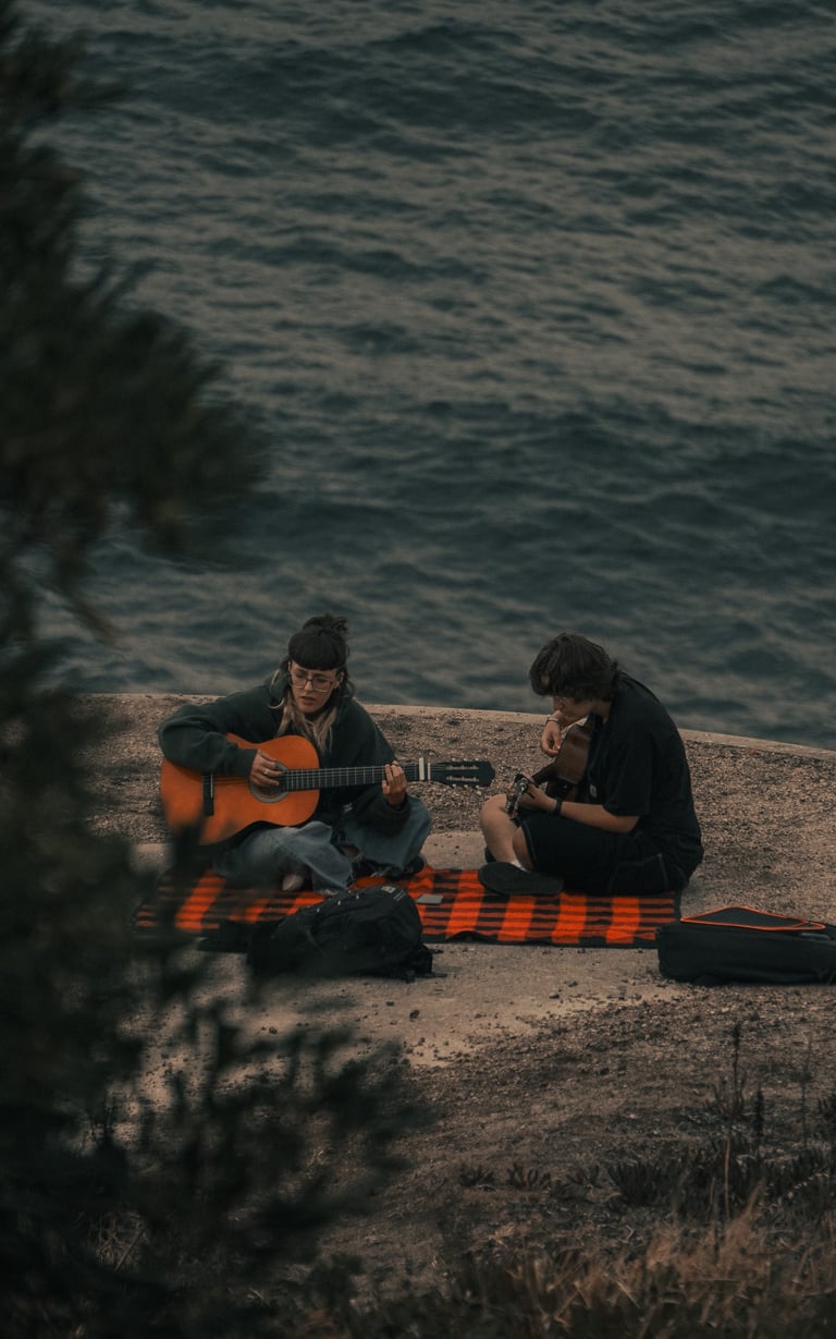 Forografía de dos personas tocando la guitarra en el Monte de San Pedro, A Coruña