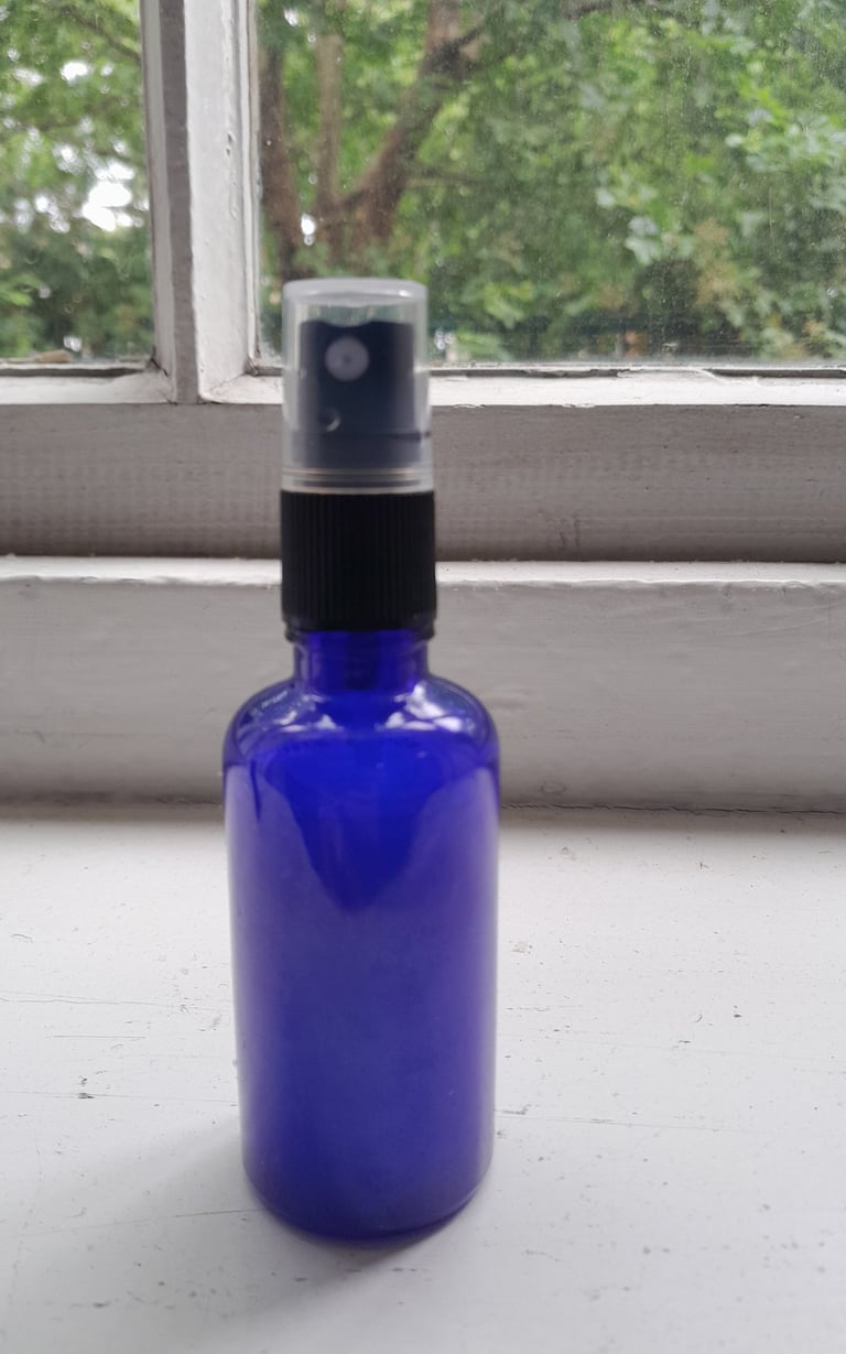 An image of a homemade therapy product called Vibrational Room Spray in a blue spray bottle..