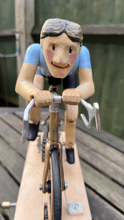 Front view of cyclist showing painted face and hands gripping handlebars