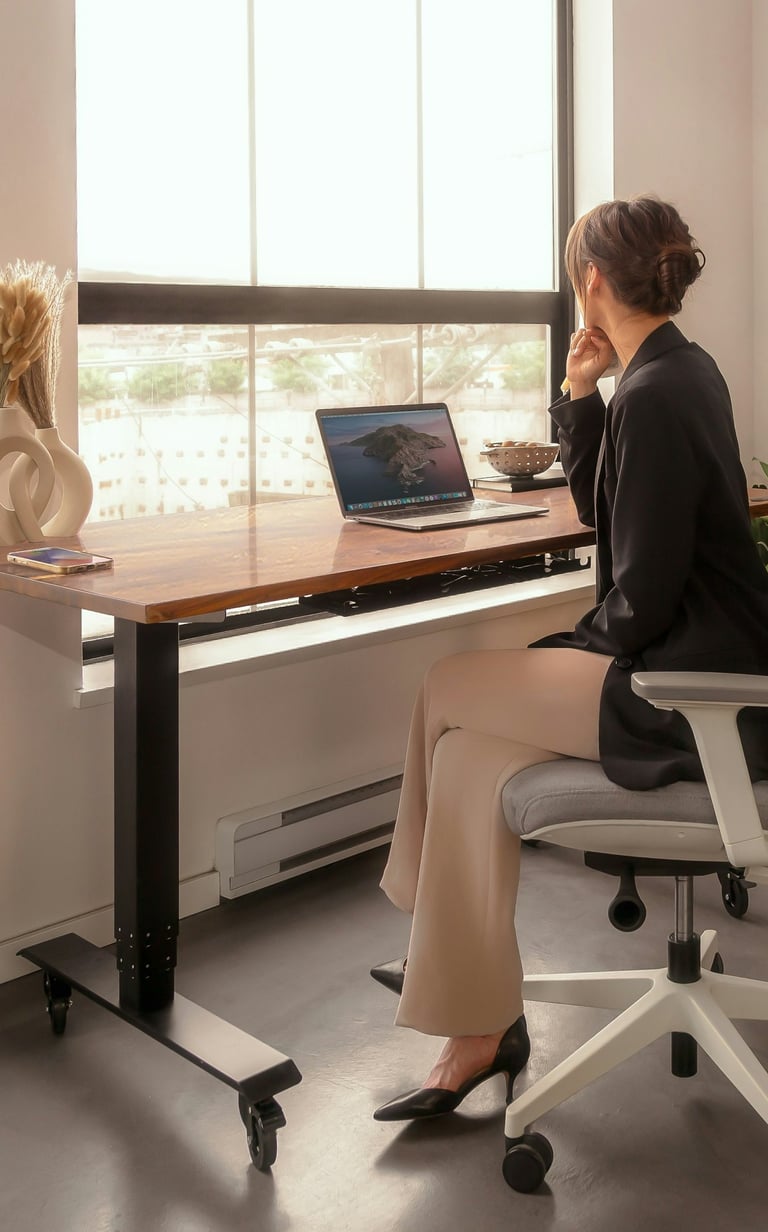 A businesswoman sitting in front of a desk with an open laptop.