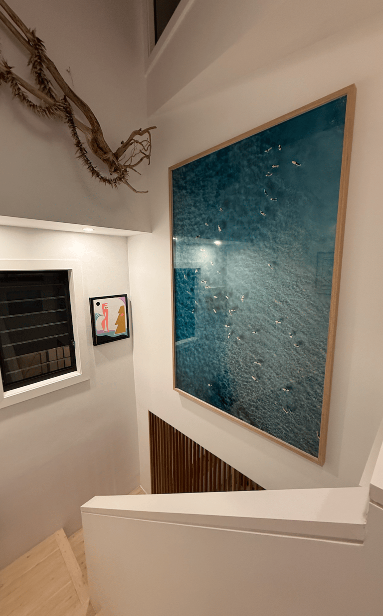 a large artwork hung in a staircase void