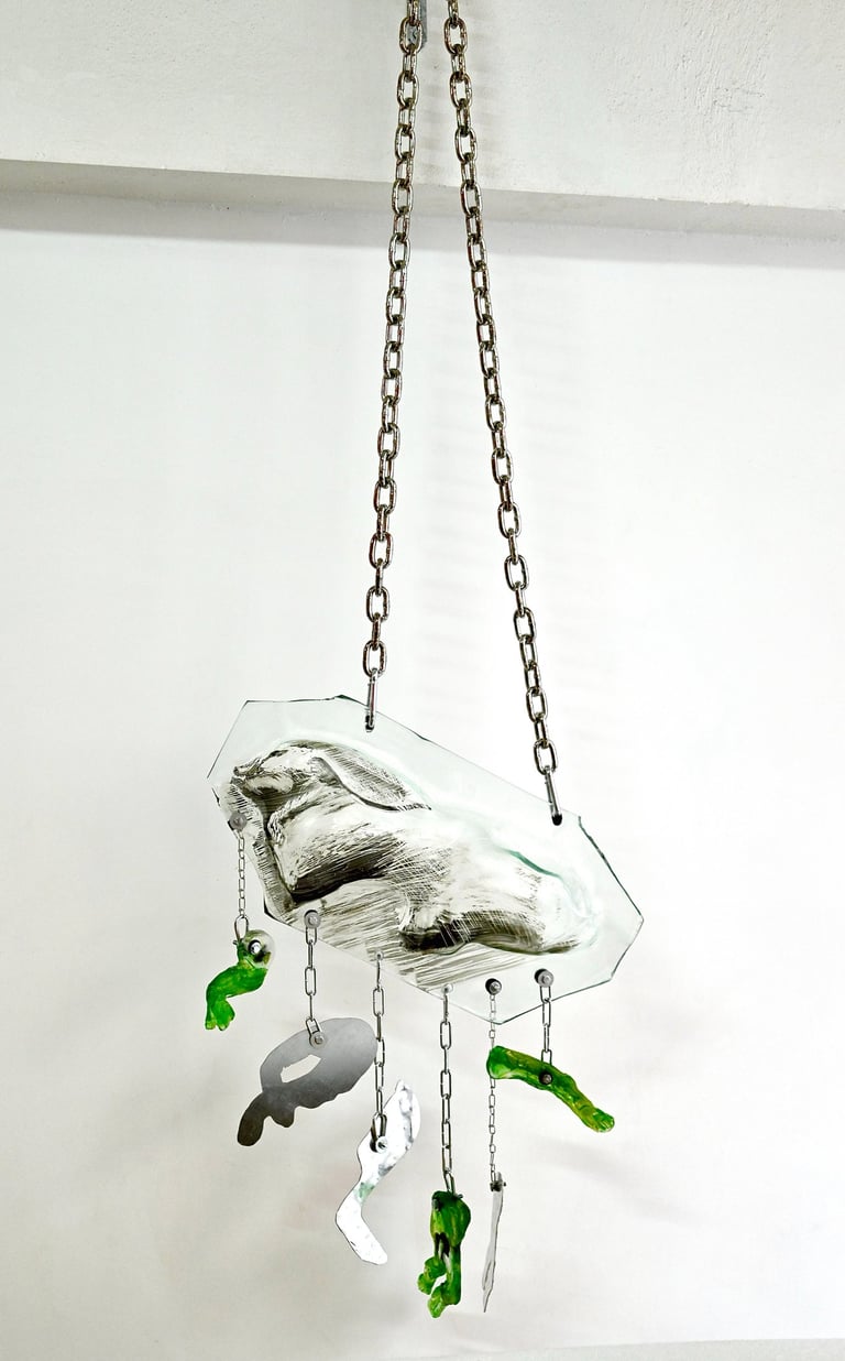 a glass sculpture of a bird hanging from a chain