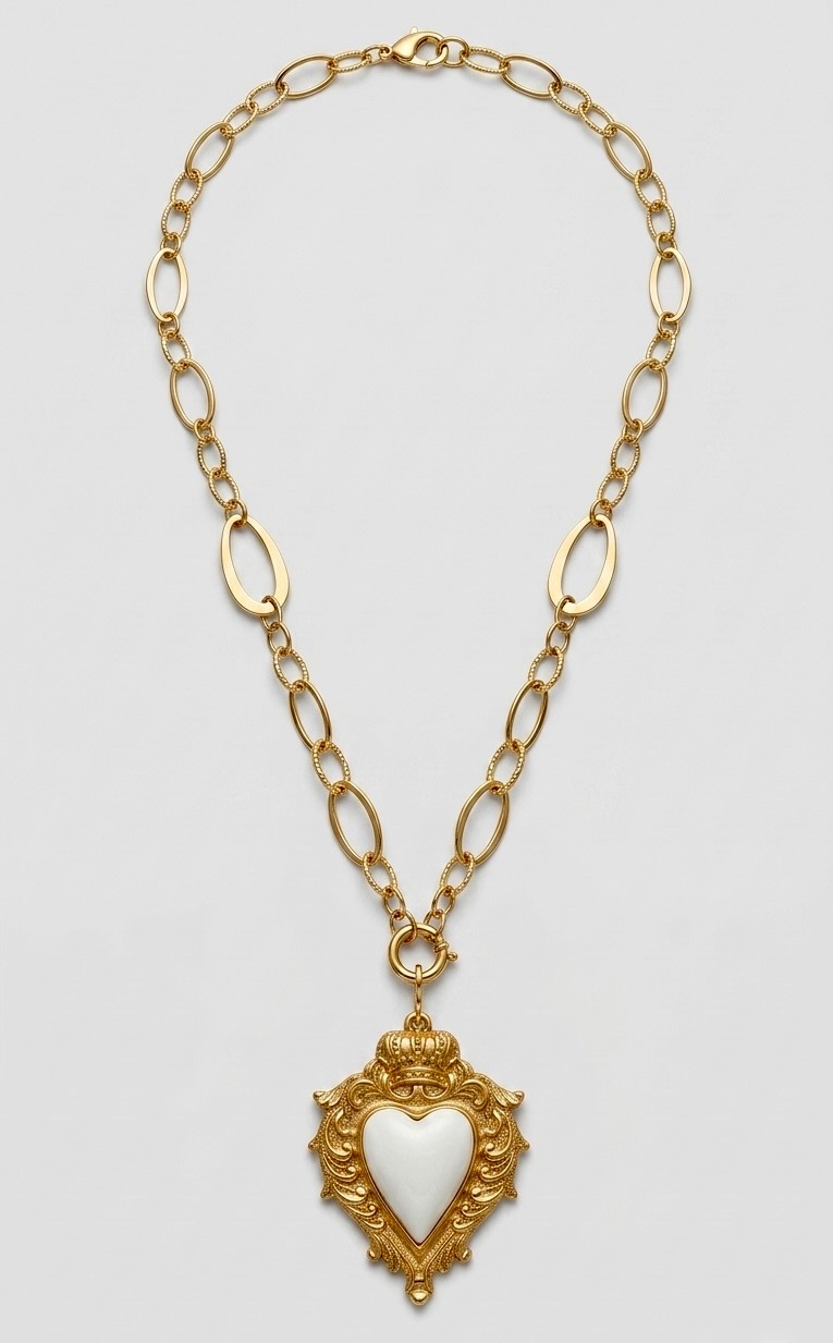 Gold chain necklace featuring a vintage crowned heart pendant with a white stone center.