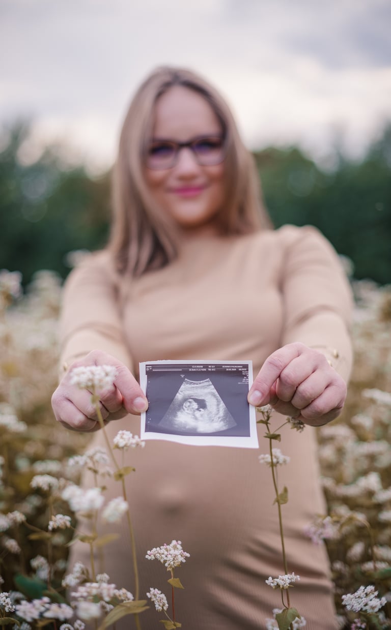 Nėštumo fotosesija - echoskopijos nuotraukytė tarp gėlių