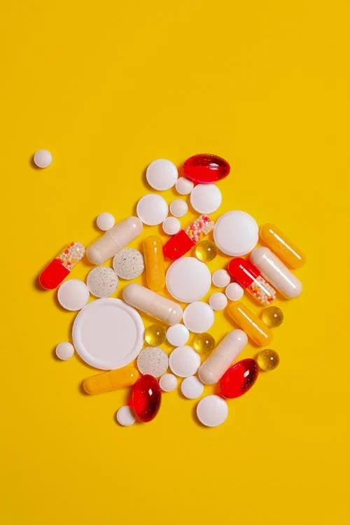 a variety of pills and pills on a yellow background