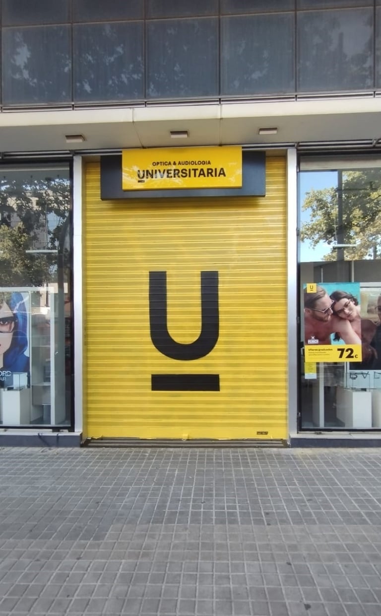 Graffiti en persiana, cierre metálico de Óptica Universitaria, Barcelona