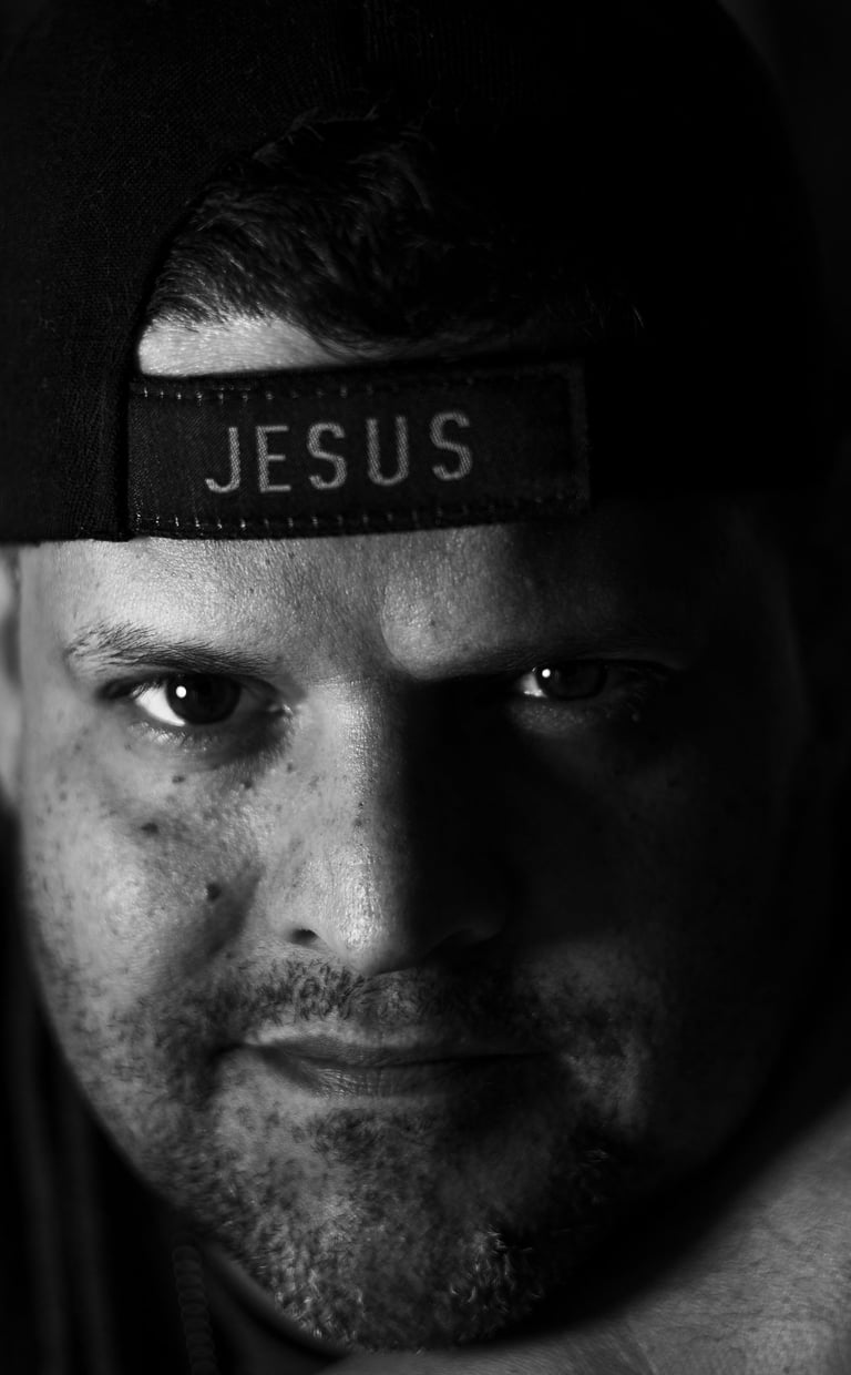 Black & White image of Bryan Avila wearing a hat that says Jesus