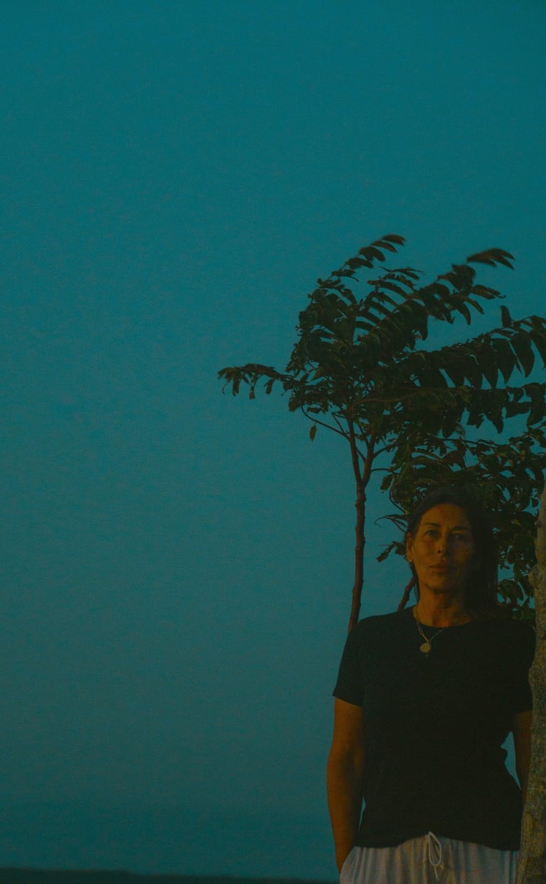 a woman standing in front of a tree