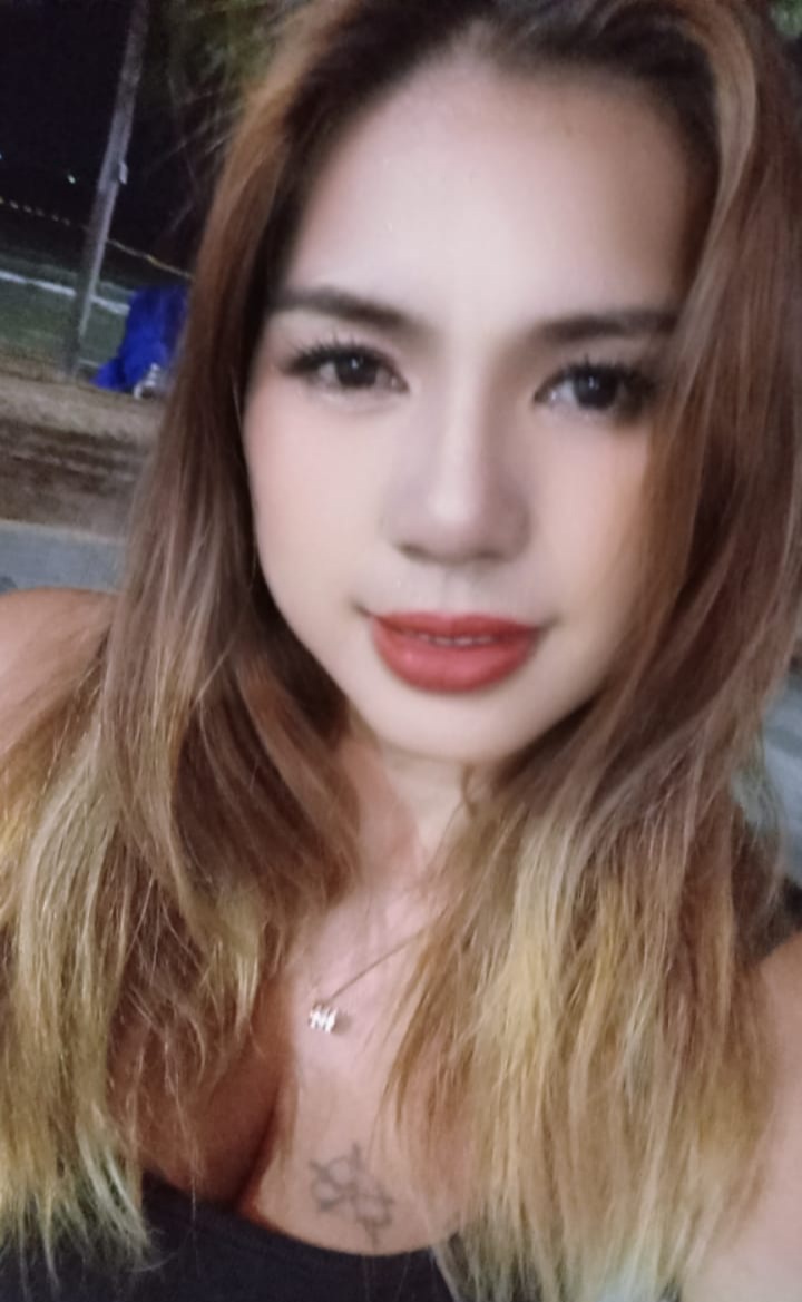 Experienced home massage therapist in Pattaya with a friendly and welcoming appearance, photographed in a night market