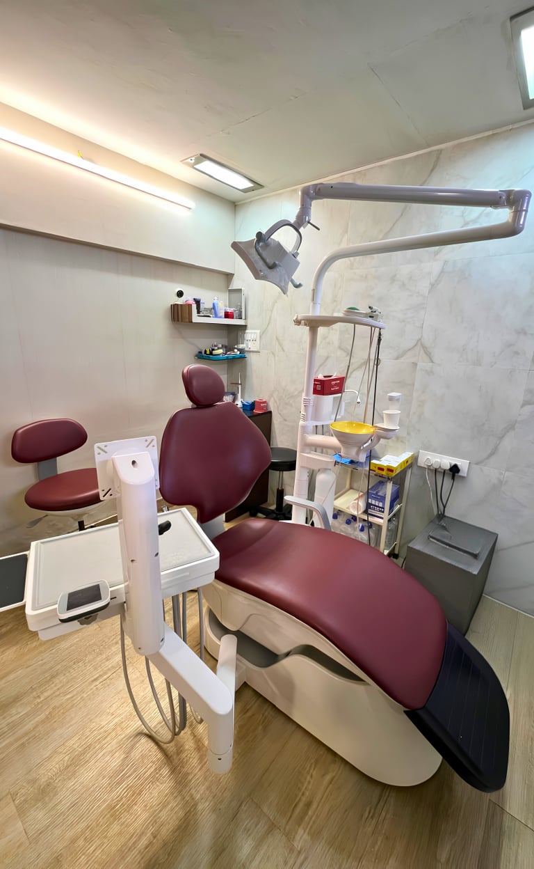 Modern dental clinic interior featuring a maroon leather examination chair and advanced medical equipment.