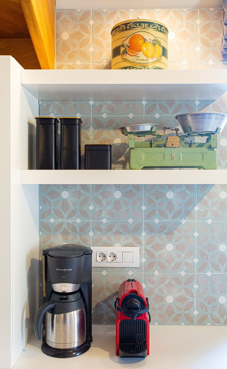 Kitchen shelves with coffee machines, storage jars, and vintage scales at Villa Skyphos in Crete