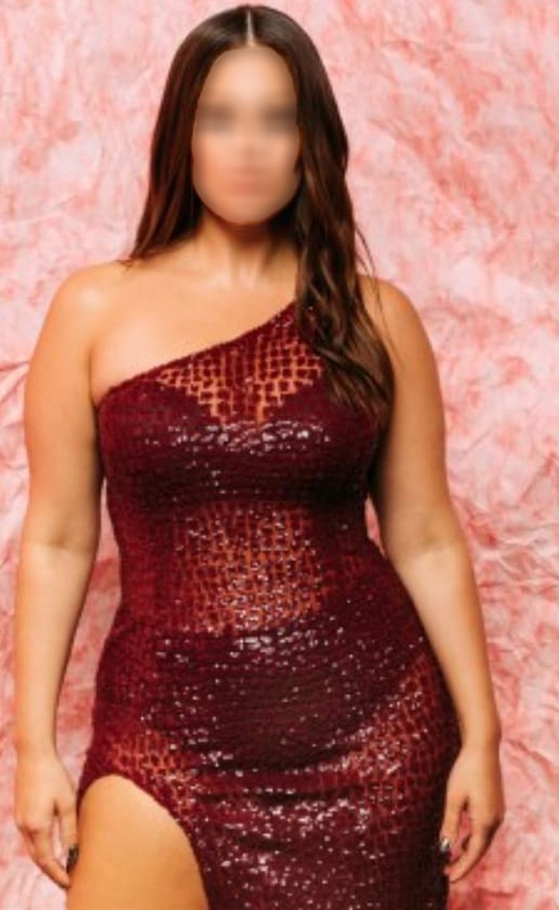 a woman in a red dress with a thigh high slit