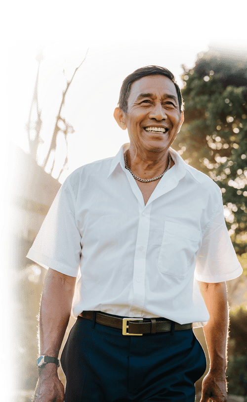 A smiling senior Asian man walking outdoors in the sunlight a stem cell therapy patient 