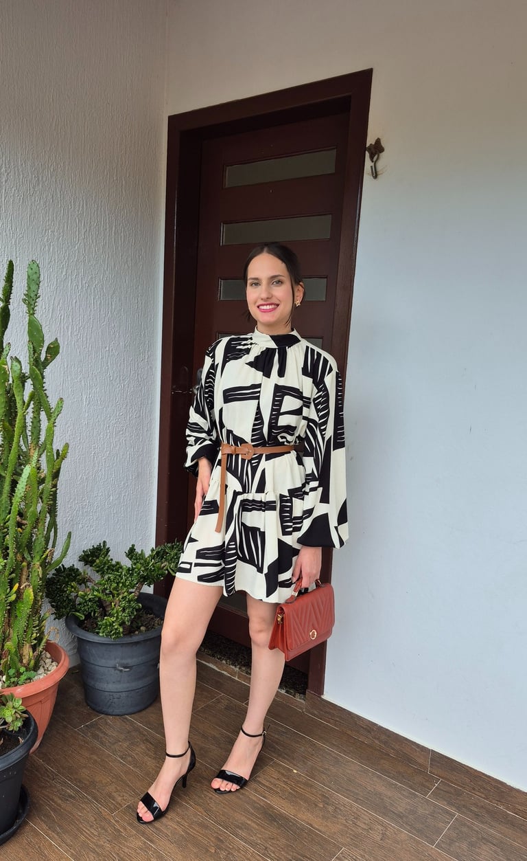 Mulher usando vestido amplo com cinto e usando uma bolsa marrom
