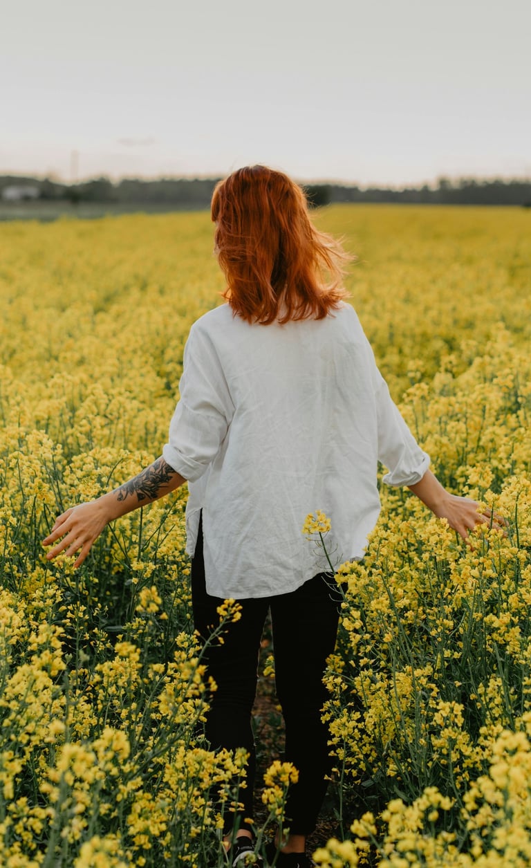 una mujer de pie en un campo de flores amarillas
