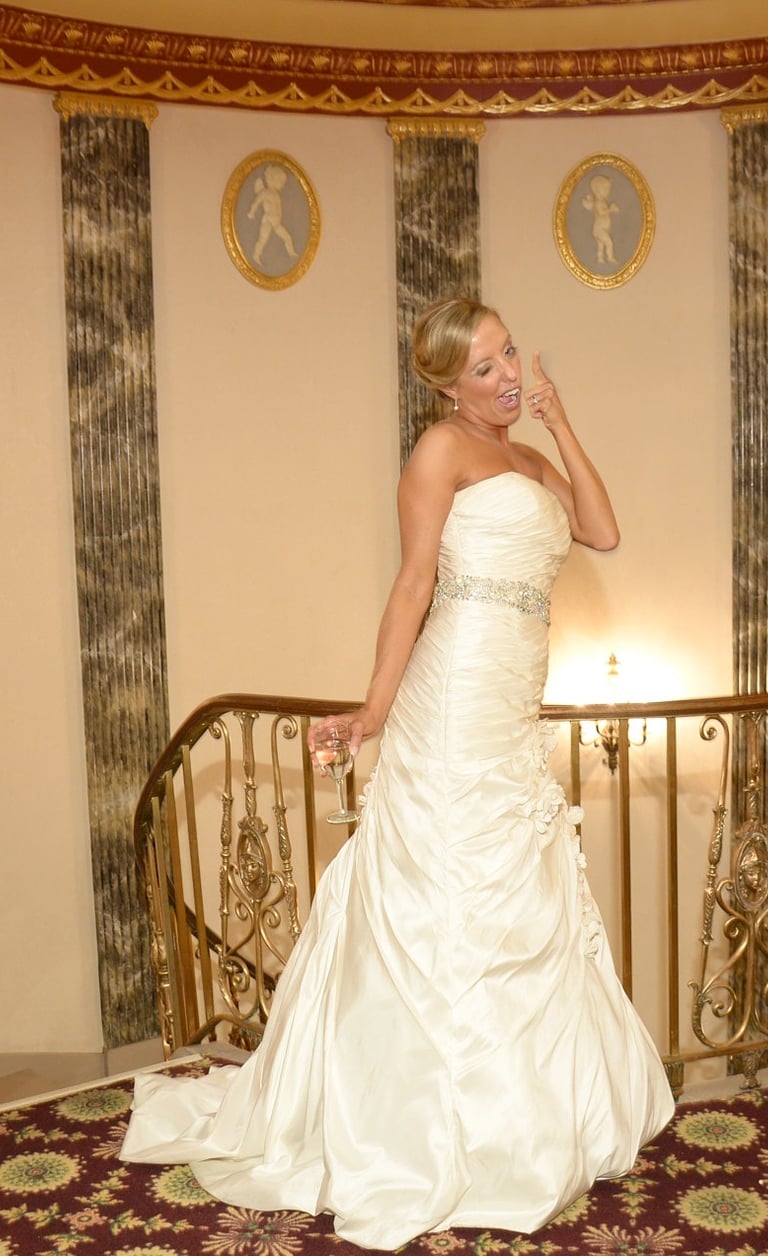 a woman in a white dress posing in the hotel lobby