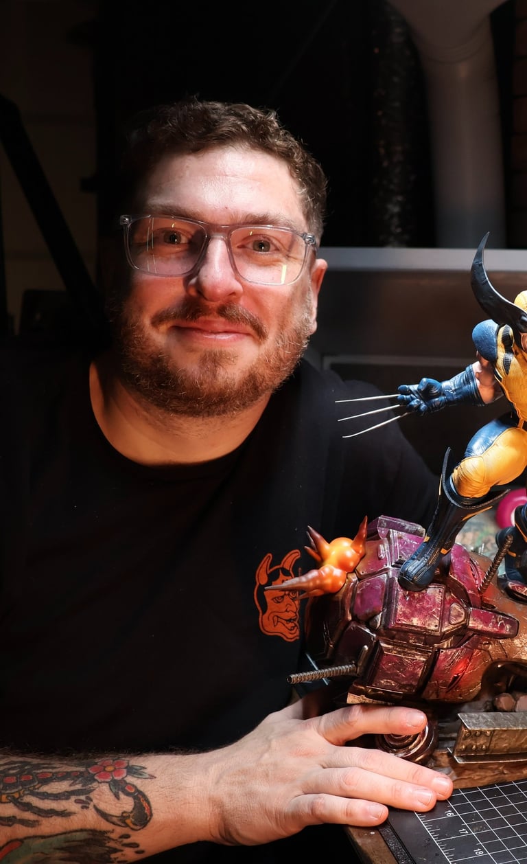 Ryan hand-painting a Wolverine statue at the Heavy Handed Studio workbench