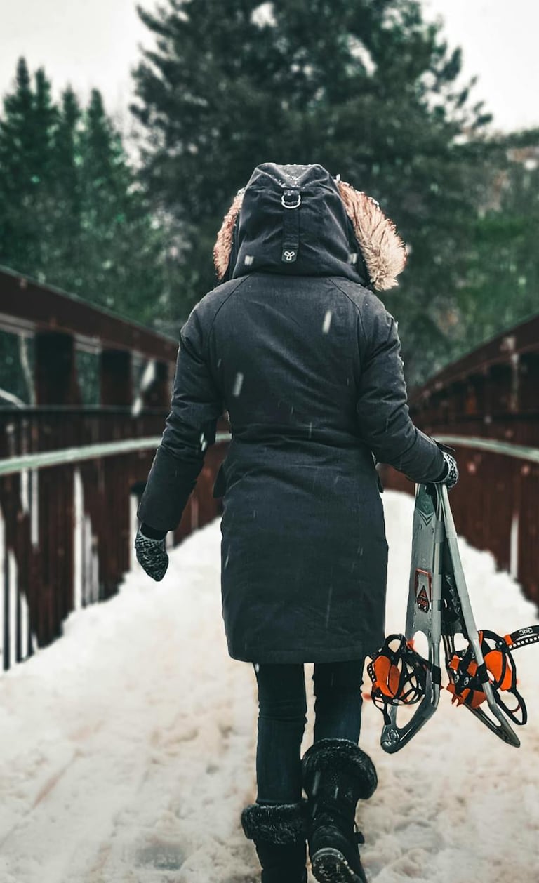 mujer cruzando un puente con nieve