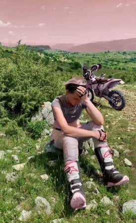 yogalehrerin-anja-sitzt-koerperlich-und-mental-am-ende-in-bosnischer-berglandschaft-neben-motorrad