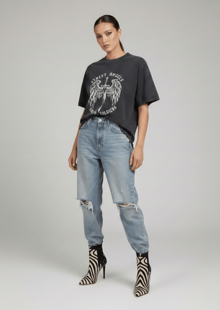 Woman wearing an oversized graphic t-shirt, distressed blue jeans, and zebra print stiletto boots.