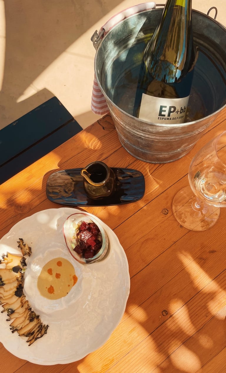 a table with abalone and a wine glass and a bottle of sparking wine