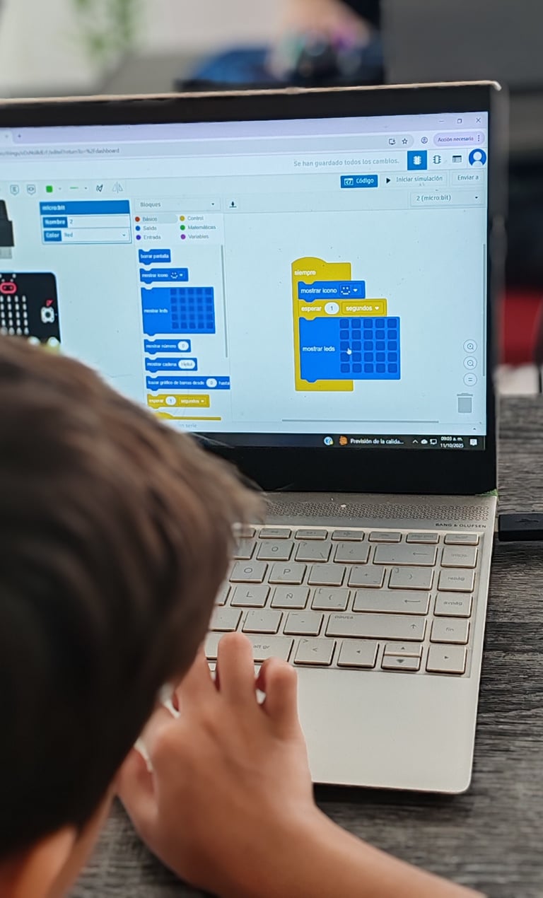 Niño aprendiendo programación por bloques en una computadora.