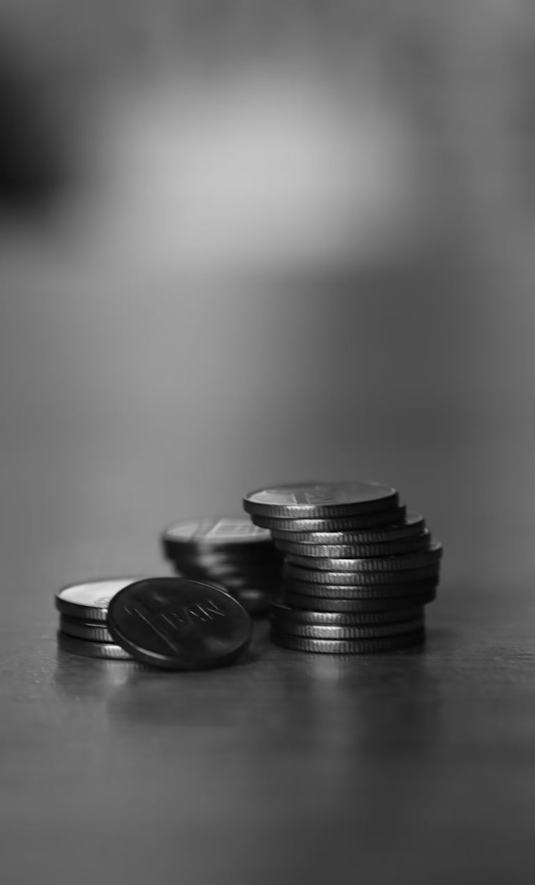 Tres pilas de monedas sobre una mesa.