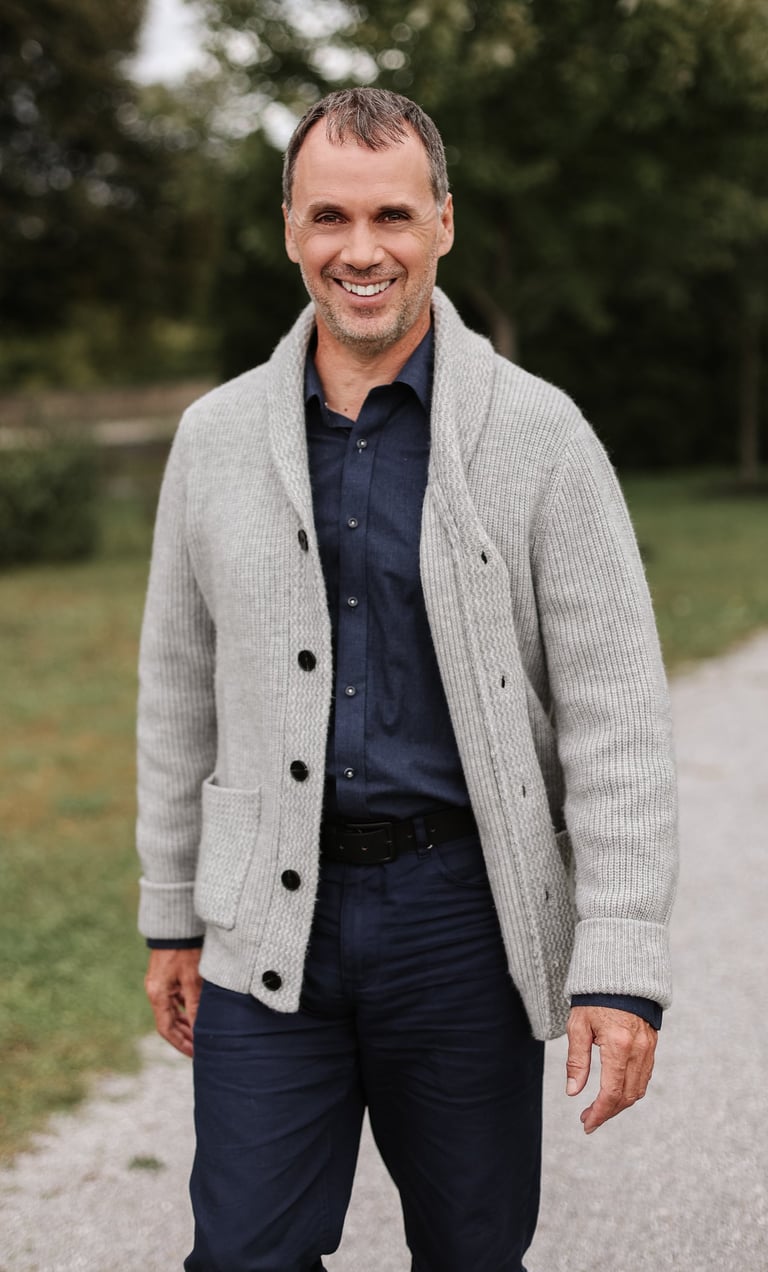 Martin Doucet souriant, debout à l’extérieur en tenue professionnelle décontractée. - Célébra.ca