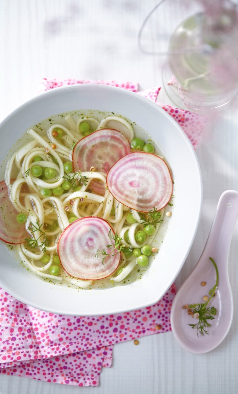 a bowl of soup with radishes and peas