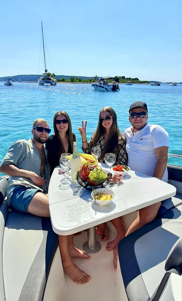 Group celebrating a birthday at Blue Lagoon on a boat, sitting around a table with fruit and drinks on private tour in Split