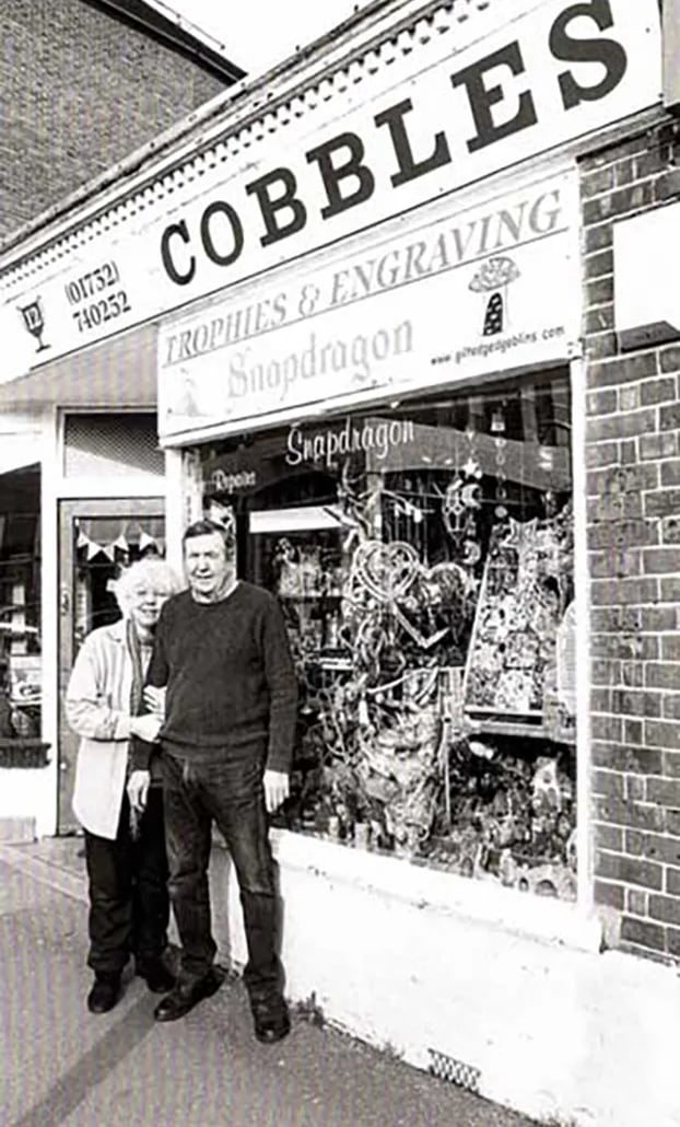 a man and woman standing in front of a store
