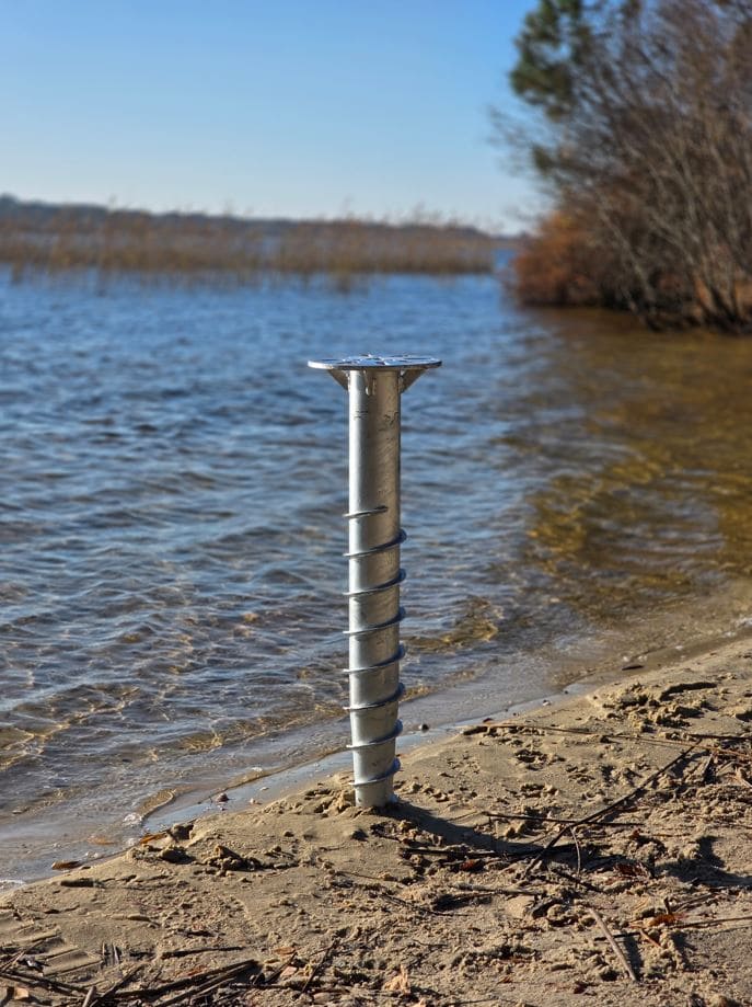 Pieu métallique dans le sable qui remplace un plot béton