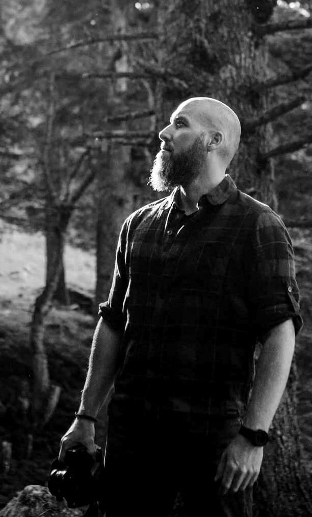 Homme debout dans une forêt.