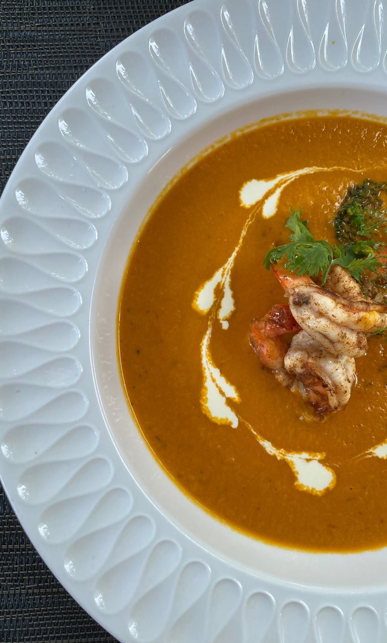 a bowl of soup with a lobster and broccoli